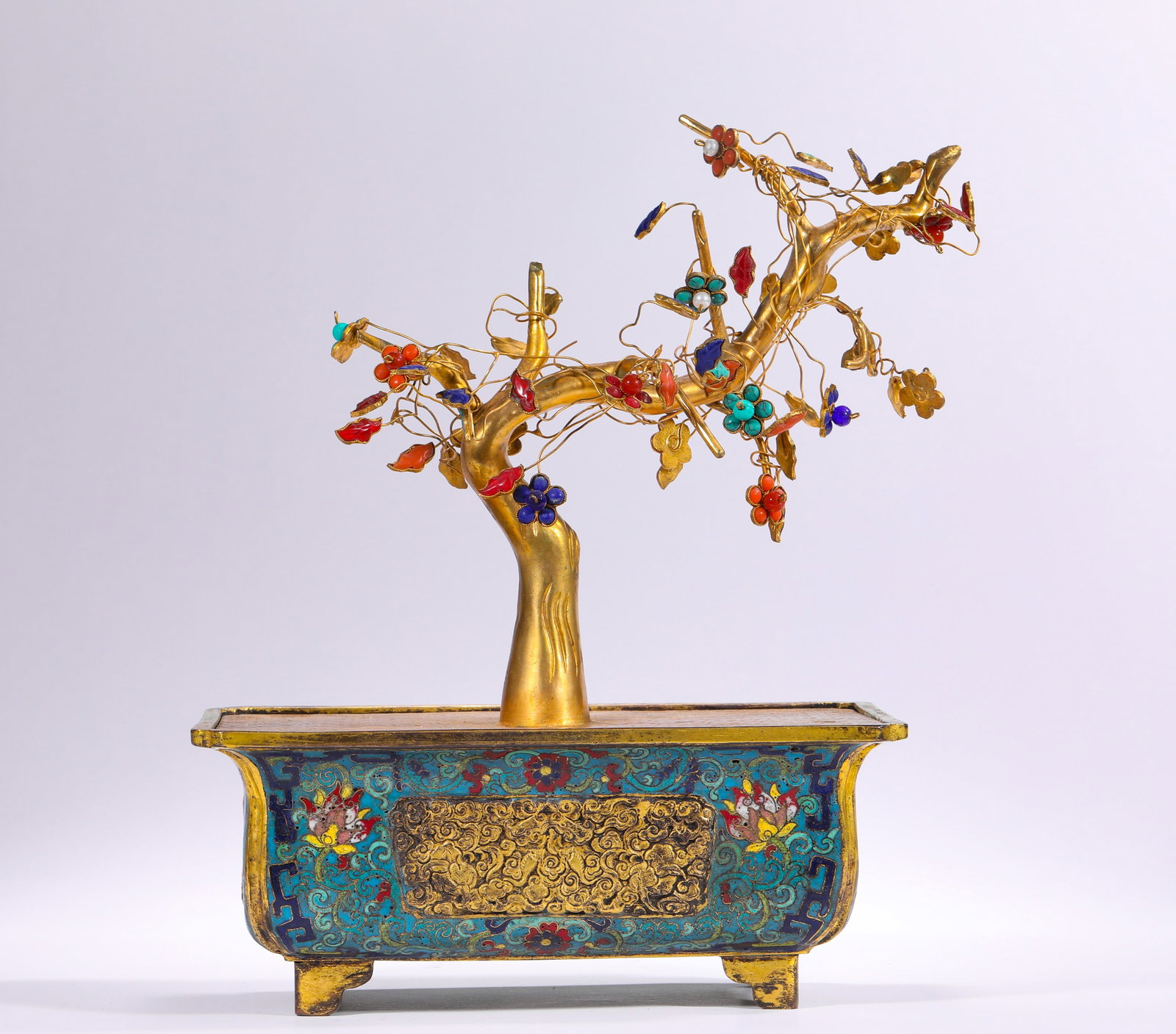 BRONZE GILDED CLOISONNE INLAID GEM BONSAI OF THE QING DYNASTY: H:28.0cm(11.02in) W:21.0cm(8.27in) Weight:1490g(3.28lb)This bonsai is a masterpiece of the craftsmanship of the Qing Dynasty Imperial Workshop. Made of bronze with full-body gilding, the trunk and bra