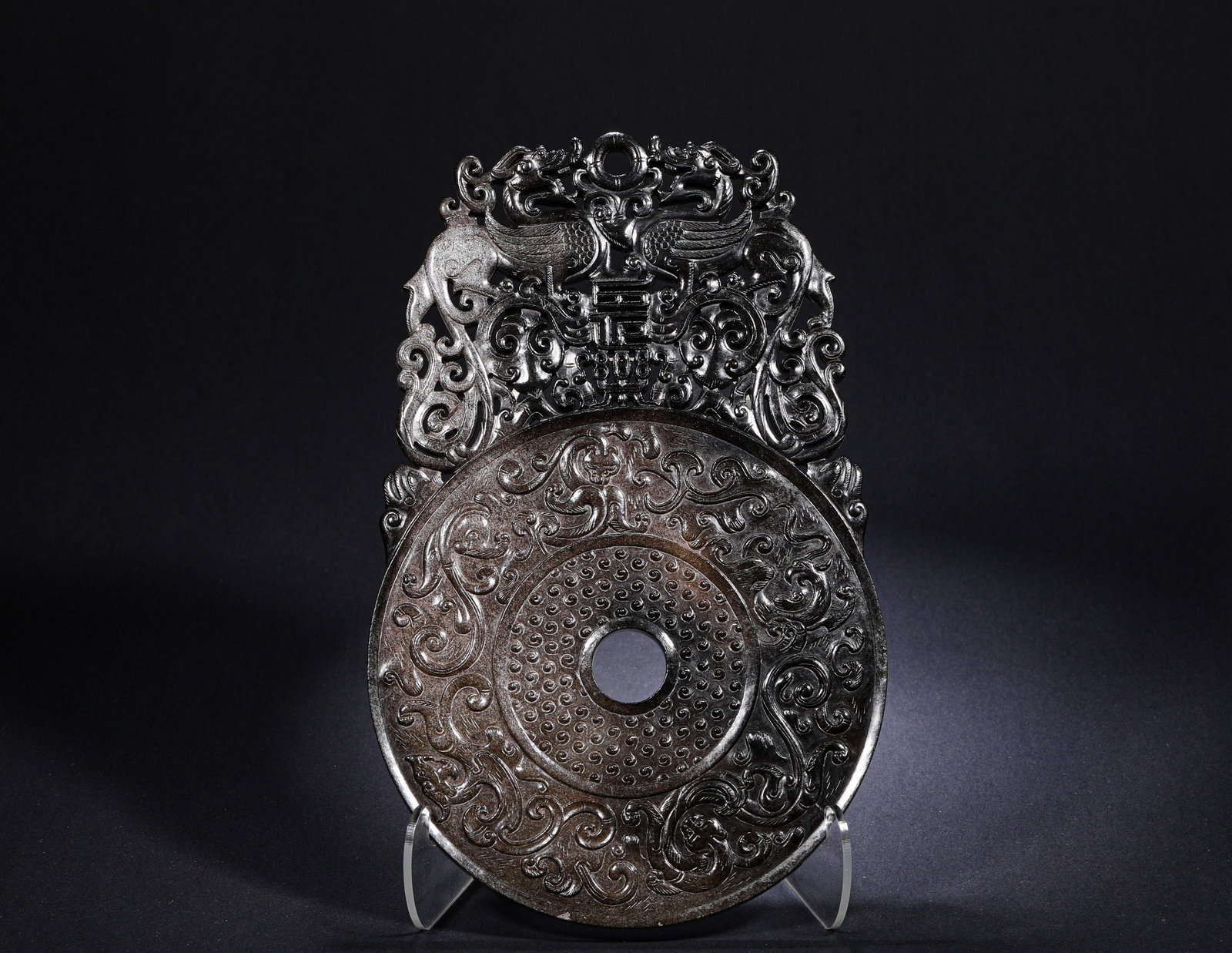HAN DYNASTY HETIAN JADE "CHANGLE" JADE DISC: H:25.5cm(10.04in) W:16.5cm(6.50in) Weight:640g(1.41lb)This is an outstretched bi disc. The main circular area is fully carved with grain patterns and surrounded by chi dragon motifs. The upper outstre