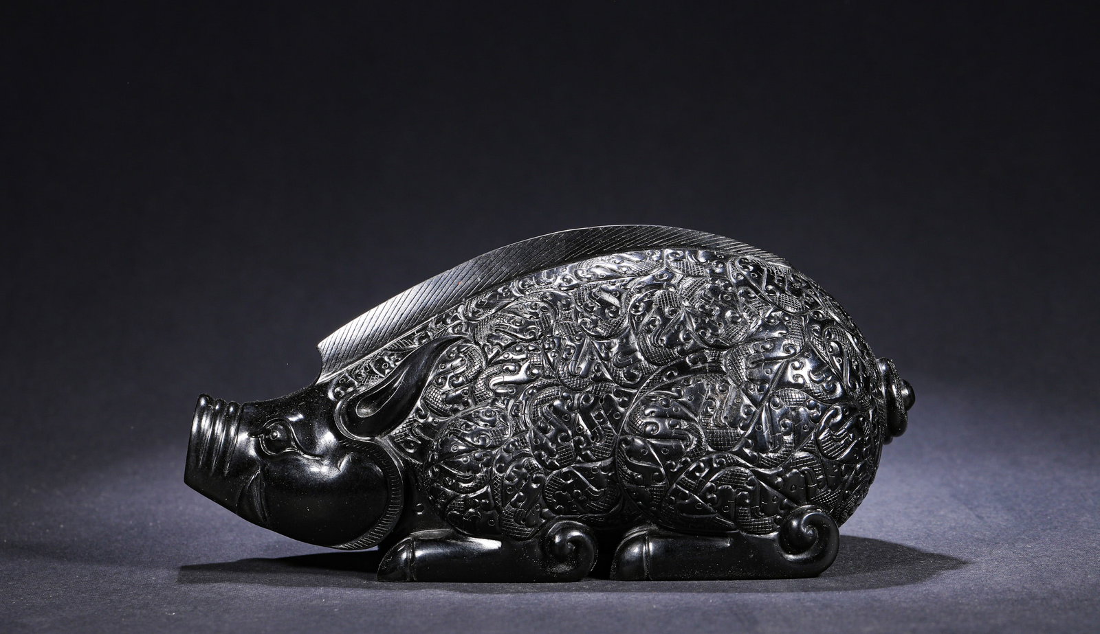HAN DYNASTY BLACK JADE WITH A FULL CHISEL DRAGON PATTERN OF A RECLINING PIG: H:7cm(2.76in) W:16cm(6.30in) Weight:1310g(2.89lb)