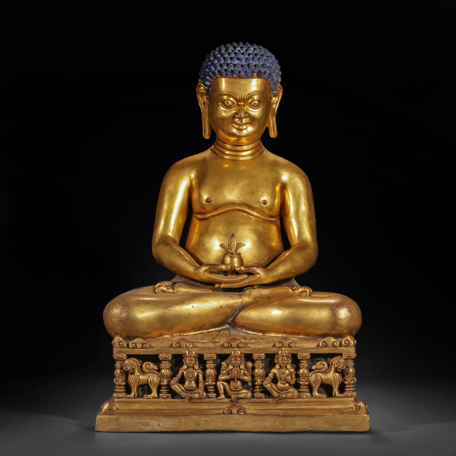 A GILDED BRONZE STATUE OF THE BUDDHA BAOSHENG FROM THE QING DYNASTY: H:50.0cm(19.69in) W:33.0cm(12.99in) Weight:19200g(42.33lb)This statue is cast in bronze and gilded. The main figure sits in the full-lotus posture on a Sumeru-style pedestal, with blue-painted hair, a