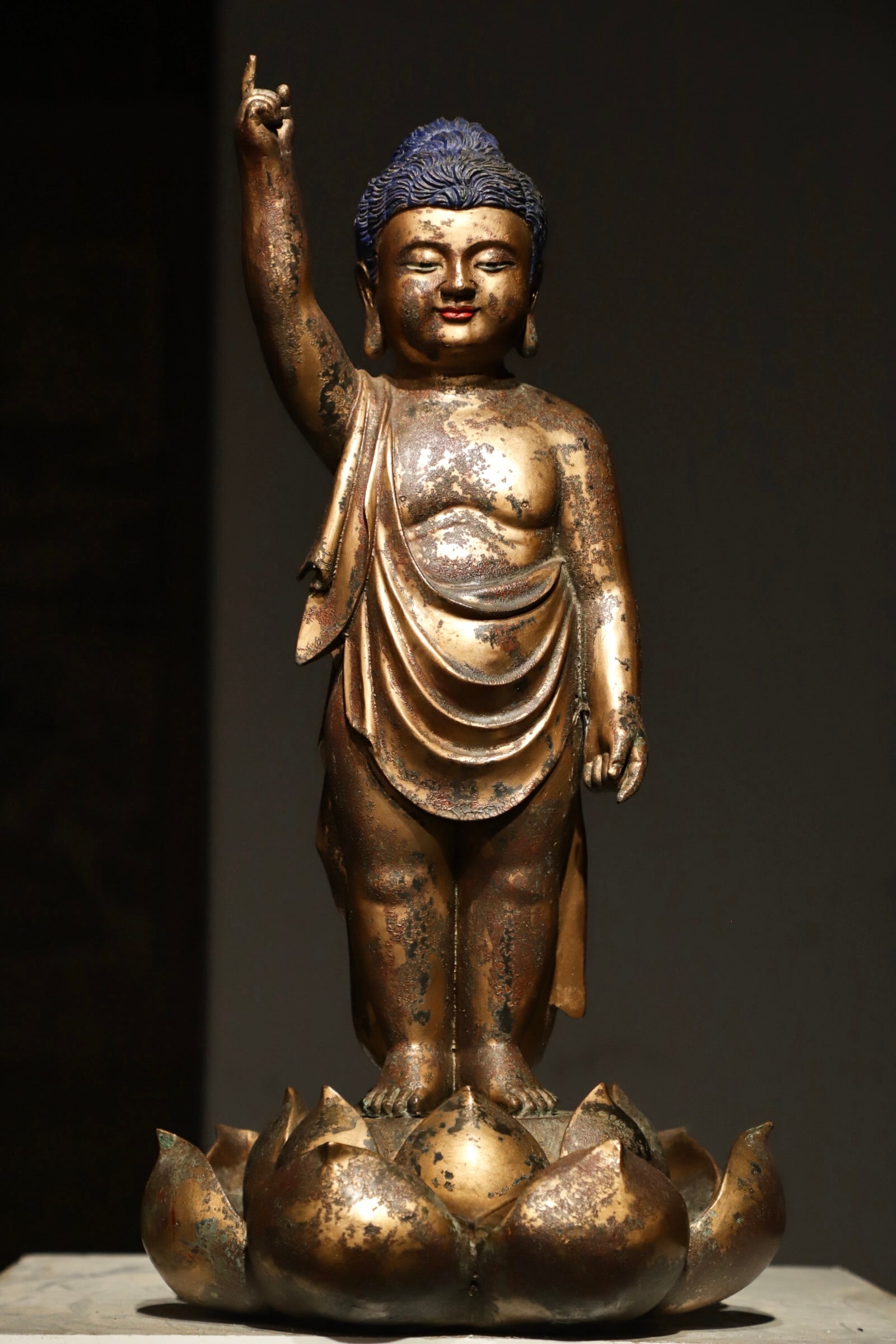 A GILDED BRONZE FIGURE OF A CHILD IN THE MING DYNASTY: H:50cm(19.69in)D:26cm(10.24in)Weight:9400g(20.72lb)The solid heavy bronze body is fully covered in ancient gilding layer, which formed mild mottled warm patina and natural aged oxidation traces after 