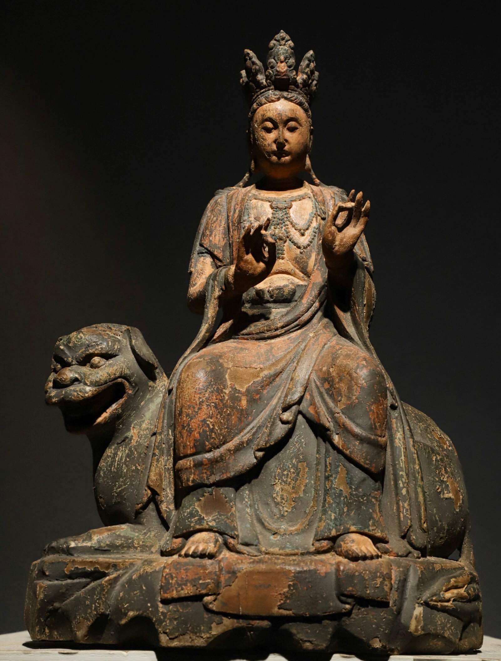 A GILDED MANJUSRI BODHISATTVA STATUE FROM THE MING DYNASTY: H:45cm(17.72in)L:29cm(11.42in)W:17cm(6.69in)The solid ancient wood bears deep mild natural old patina after centuries of erosion with naturally faded original mineral pigment traces, profound weathere