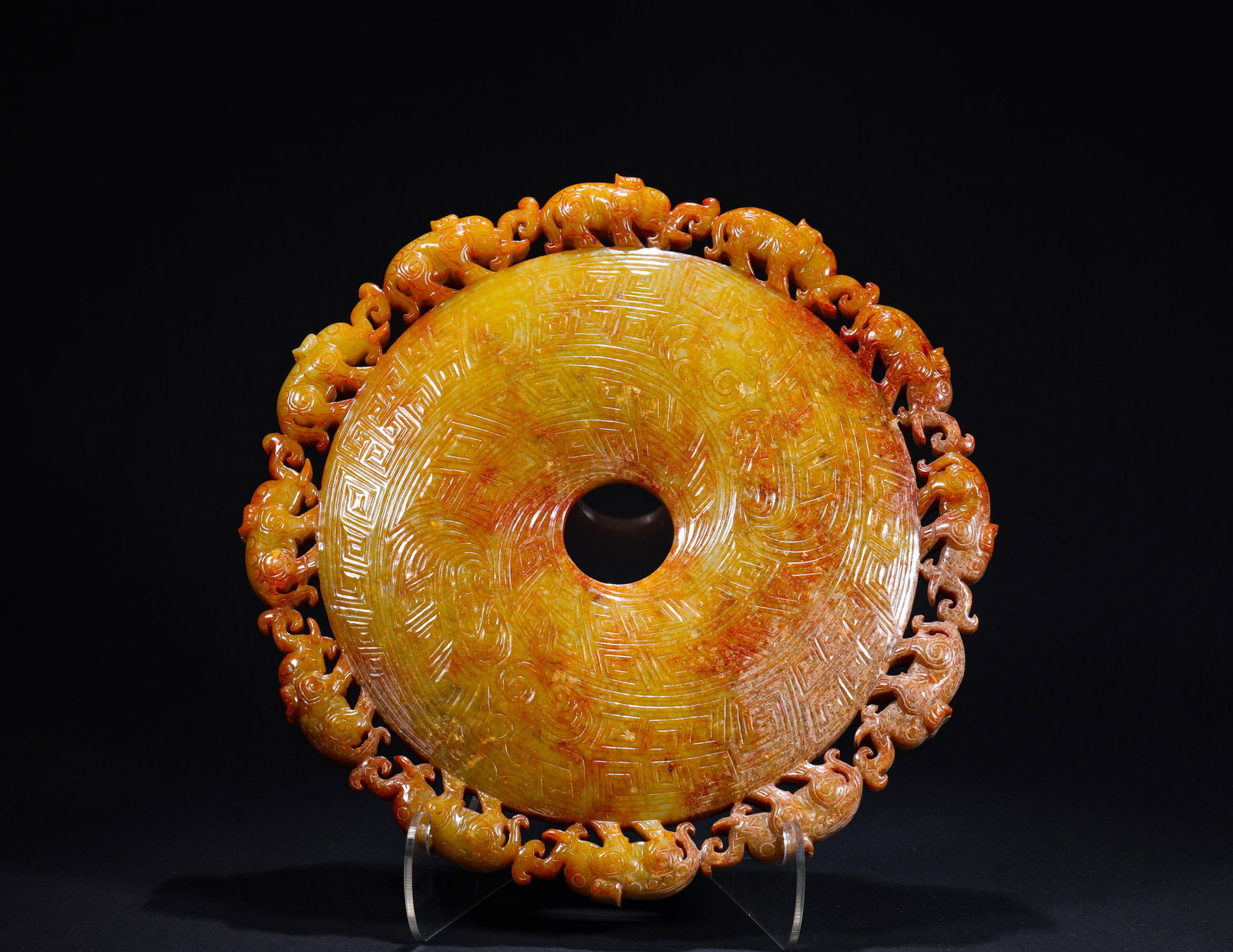 ANCIENT HAN DYNASTY JADE WITH A PATTERN OF AUSPICIOUS BEASTS: D:24.5cm(9.65in) Weight:1980g(4.37lb)This is an ancient jade bi disc with openwork auspicious beast patterns on the outer rim, featuring yellowish-brown calcified jade, intricate carvings of meander a
