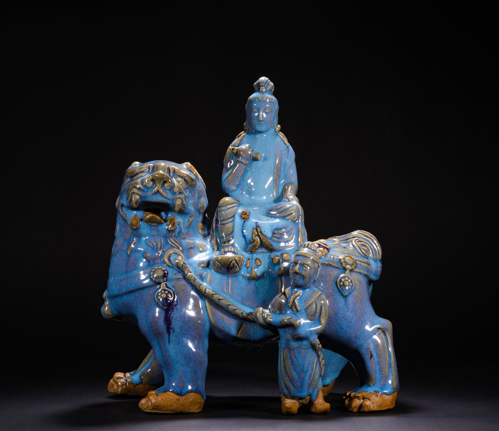 YUAN DYNASTY JUN GLAZE IMAGE OF MANJUSRI BODHISATTVA RIDING A LION: H:37.0cm(14.57in) W:28.0cm(11.02in)This statue is a classic Buddhist figure of the Jun Kiln system. The main figure Manjushri Bodhisattva sits in lotus position on the back of a blue lion, holding a r