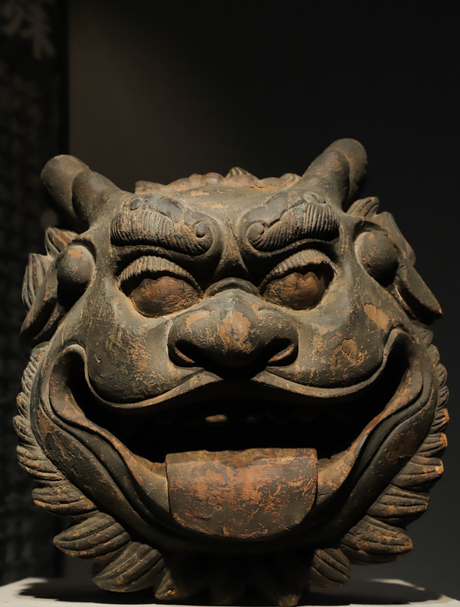 AN OLD WOODEN CARVING OF THE HEAVENLY KING WITH A MOUTH FROM THE MING DYNASTY: H:38cm(14.96in)W:38cm(14.96in)T:18cm(7.09in)The solid dense wood bears deep restrained ancient natural patina after centuries of erosion, with calm aged color and profound weathered wood texture, well