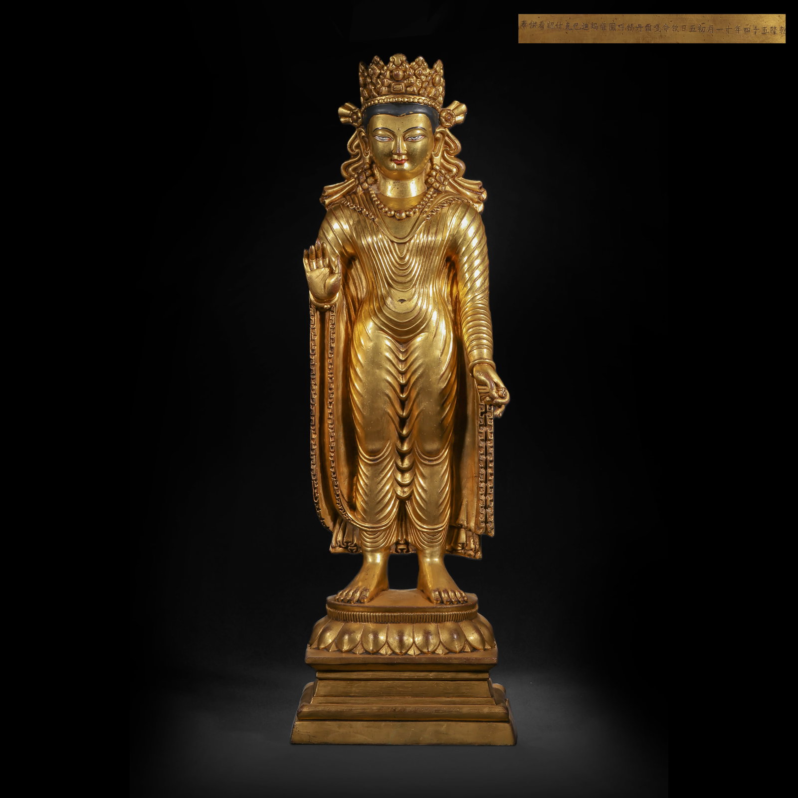 A GILDED BRONZE CROWN OF SAKYAMUNI BUDDHA FROM THE QING DYNASTY: H:71.0cm(27.95in) W:21.0cm(8.27in) Weight:14700g(32.41lb)This statue is cast in bronze and gilded. The main figure stands on a lotus pedestal, wearing a five-leaf treasure crown with a compassionate a