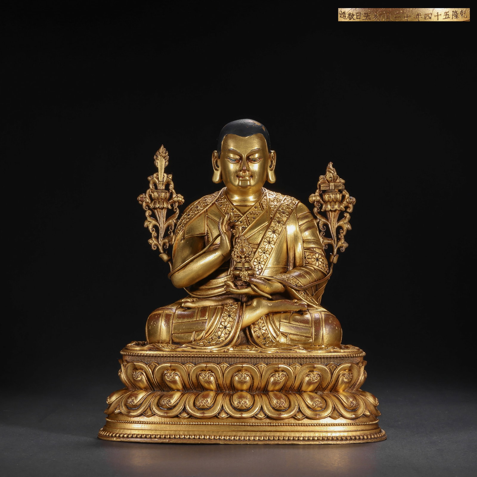 A GILDED BRONZE SITTING STATUE OF MASTER TSONGKHAPA FROM THE QING DYNASTY: H:21.0cm(8.27in) W:17.0cm(6.69in) Weight:2230g(4.92lb)This statue is cast in bronze and gilded. Tsongkhapa sits in lotus position on a double lotus pedestal, wearing a Pandita hat and monk's robes wit