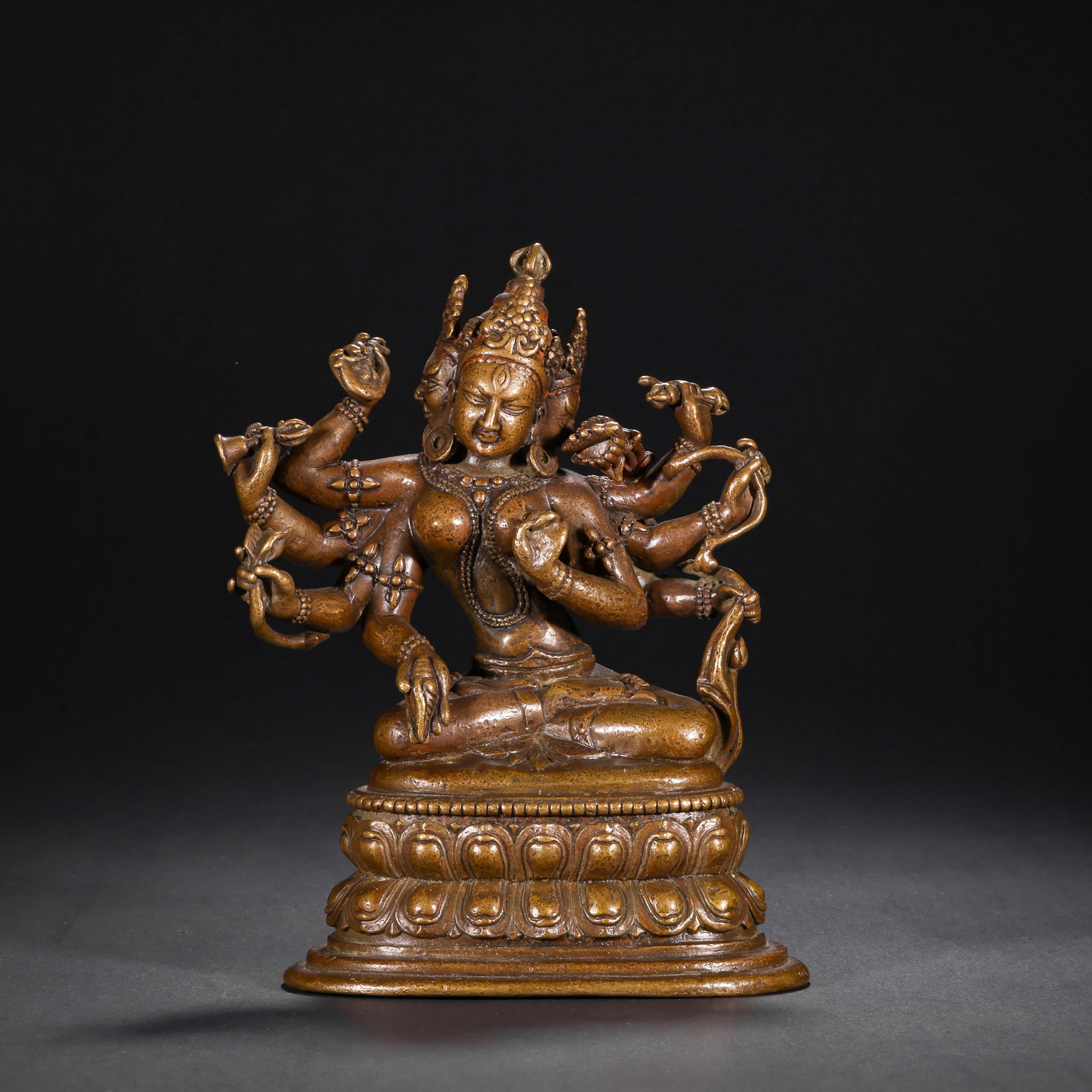 BRONZE SEATED STATUE OF THE BUDDHA OF WEALTH CONTINUATION FROM THE QING DYNASTY: H:28.5cm(11.22in) W:12.8cm(5.04in) Weight:1740g(3.84lb) This statue is cast in bronze. Vasudhara sits in a relaxed (lalitasana) posture on a lotus pedestal, with three faces and eight arms, wearing a 