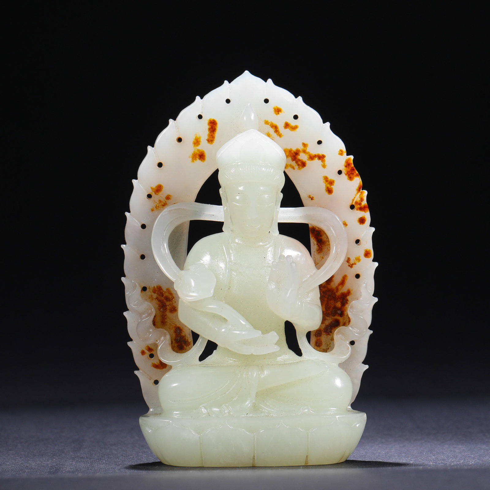 A SEATED STATUE OF GUANYIN CARVED ON THE SKIN OF HETIAN JADE IN THE QING DYNASTY: H:9.5cm(3.74in)W:6.2cm(2.44in)Weight:130g