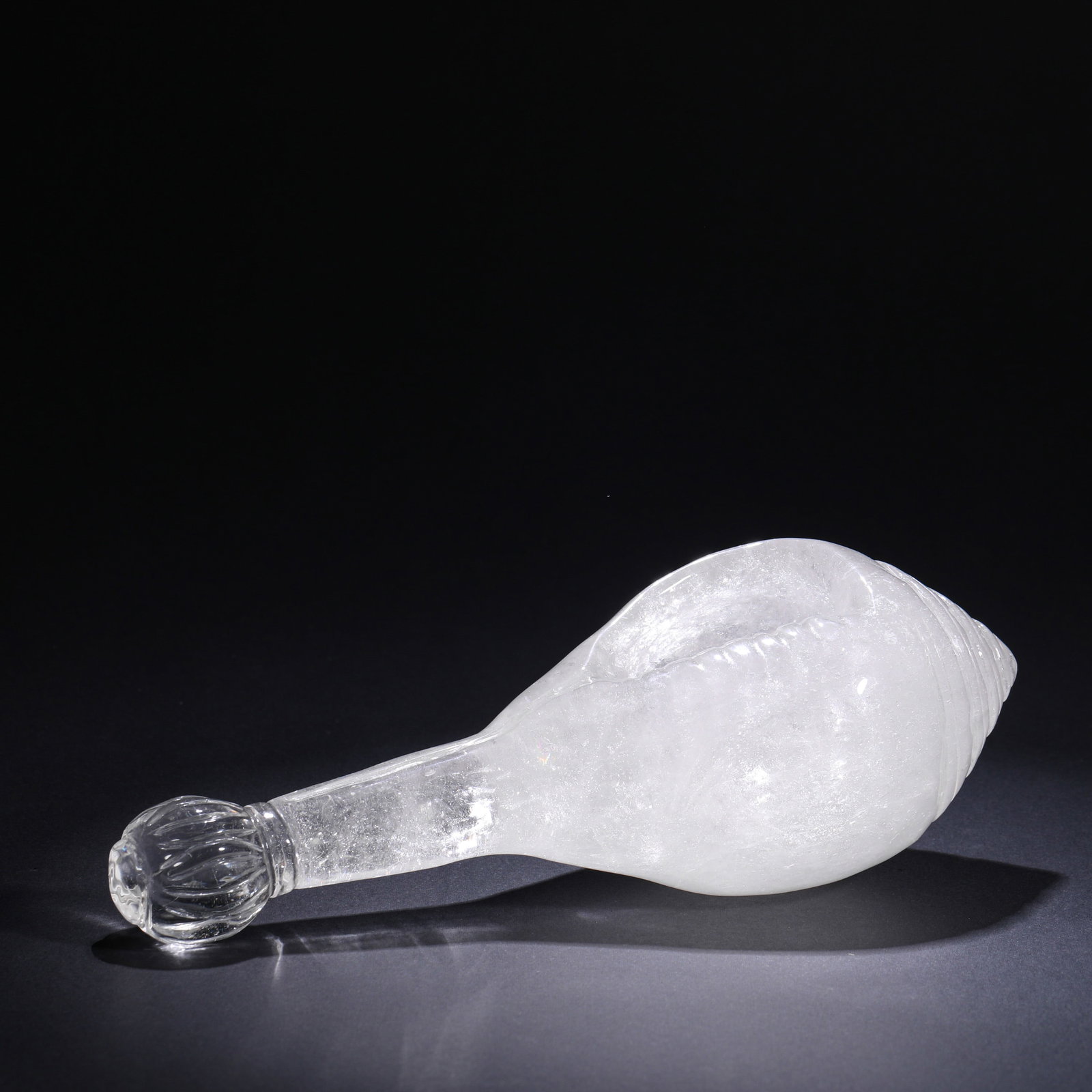 QING DYNASTY CRYSTAL-CARVED CONCH-SHAPED LONG-HANDLED INCENSE VASE: H:7cm(2.76in)W:24cm(9.45in)Weight:1200g This is a crystal carving in the shape of a conch shell with a lotus finial, dating from the Qing Dynasty or Republic of China period. Made from natural crystal
