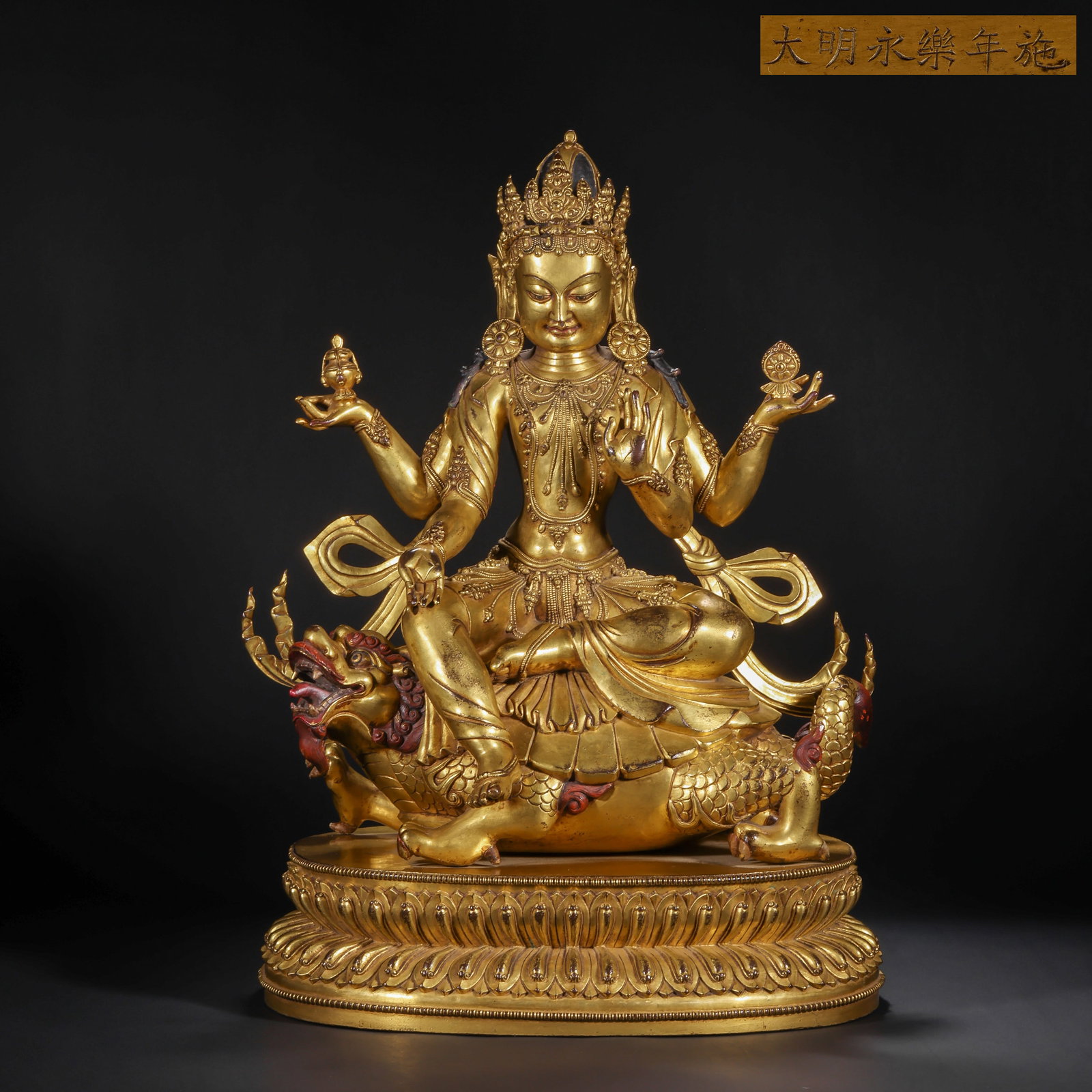 A GILDED BRONZE STATUE OF GUANYIN WITH FOUR ARMS FROM THE MING DYNASTY: H:46.0cm(18.11in) W:32.0cm(12.60in) Weight:14950g(32.96lb)This statue is cast in bronze and gilded. Four-Armed Guanyin sits in lotus position on an Ao fish (dragon turtle) divine beast, wearing a five