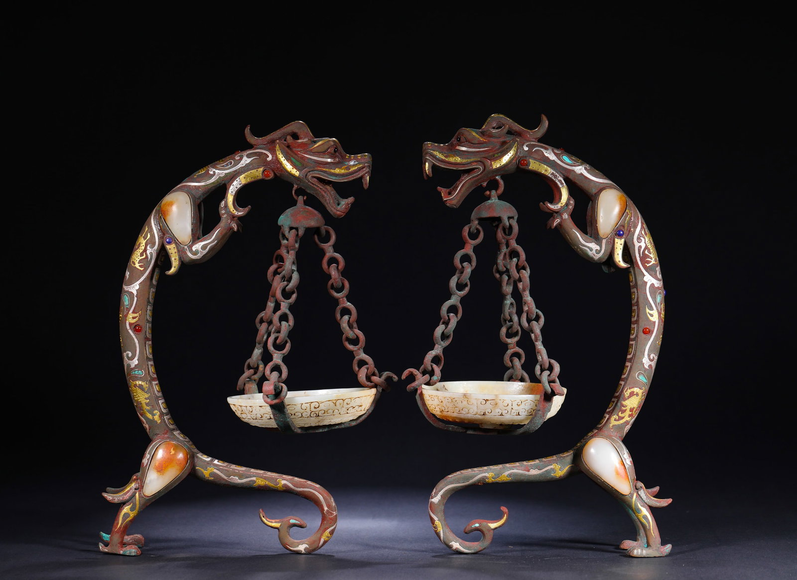 BRONZE INLAID WITH GOLD AND SILVER, JADE AND GEMSTONE, DRAGON-SHAPED PENDANT LAMP: H:32cmW:18cmWeight:4080g This is a pair of dragon-shaped hanging lamps made of bronze inlaid with gold, silver, jade and gemstones, featuring double dragon supports and hanging jade lamp plates with p