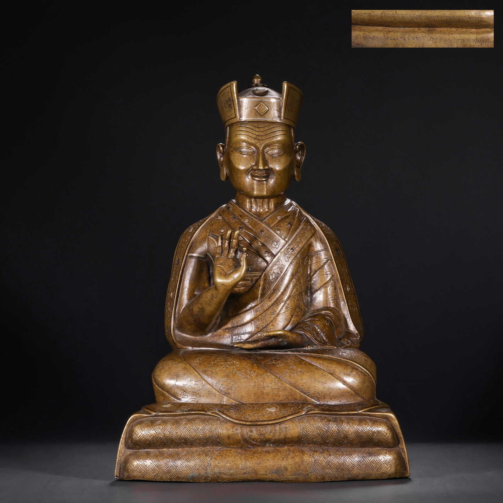 A BRONZE INLAID SILVER MASTER STATUE FROM THE QING DYNASTY: H:37.0cm(14.57in) W:22.0cm(8.66in) Weight:6300g(13.89lb)This statue is cast from copper with silver inlay craft. The main body is the image of a guru, sitting in the full-lotus posture on a pedestal. 