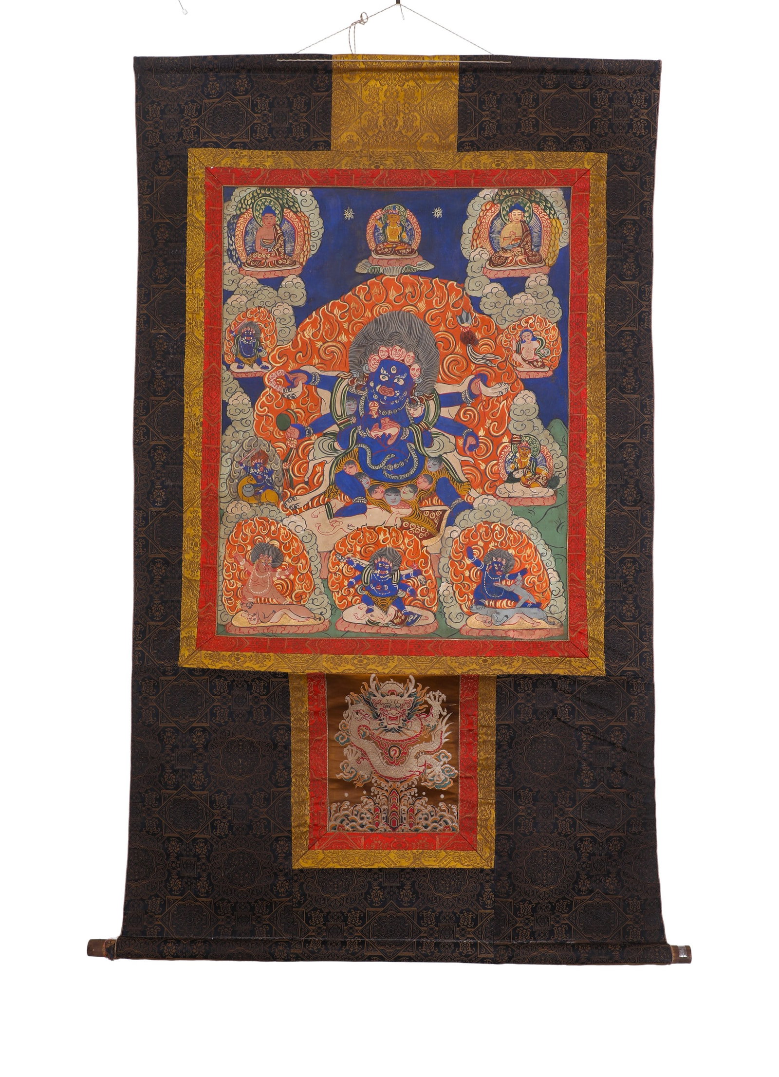 A SIX-ARMED THANGKA OF THE GREAT BLACK GUARDIAN OF THE QING DYNASTY: H:76cm (29.92in) W:60cm (23.62in)The main deity is six-armed Mahakala, with dark blue wrathful majestic appearance surrounded by intense flames. The painting is arranged with three Buddhas and attenda