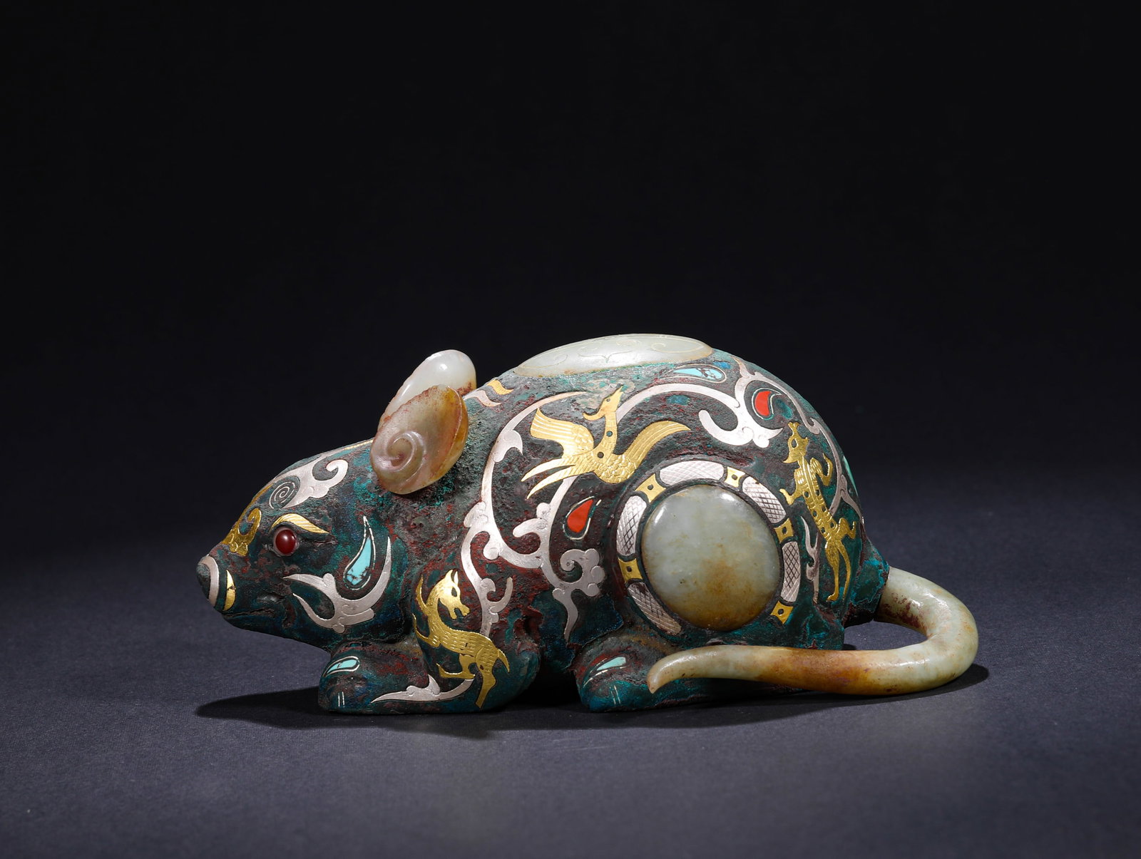 HAN DYNASTY INLAID GOLD AND SILVER INLAID JADE MOUSE-SHAPED ORNAMENT: H:6cmW:15cmWeight:540g This is a rat-shaped ornament inlaid with gold, silver, and jade. Crafted from a bronze base, it is intricately decorated with phoenix and mythical beast patterns via the gold-s