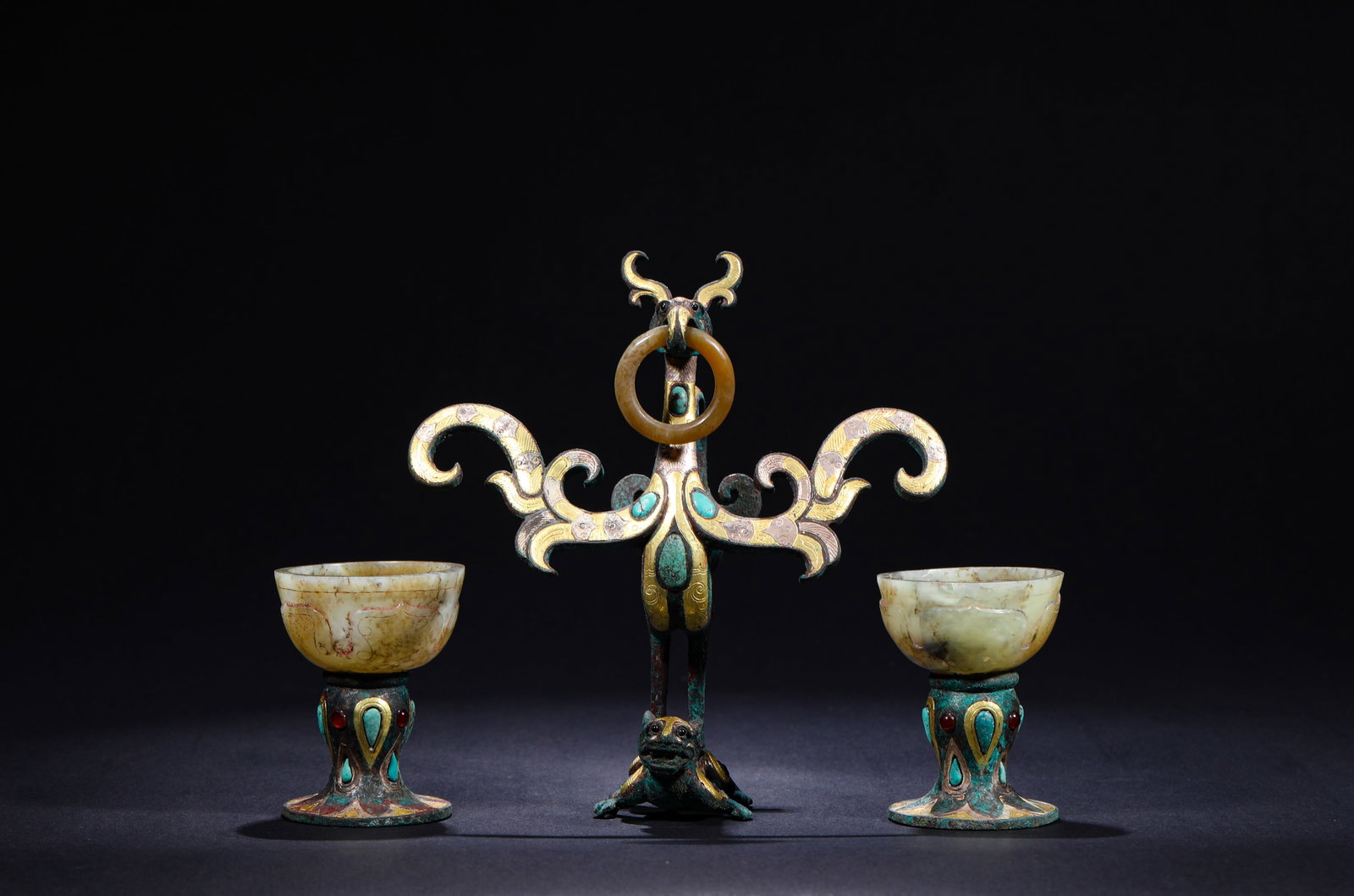 WESTERN HAN DYNASTY COPPER VERMILION BIRD WITH A RING: H:14.2cmW:13.8cmWeight:550g This is the Western Han Dynasty Bronze ?? (Vermilion Bird) Cup with Ring, entirely gold-inlaid and inlaid with turquoise. The vermilion bird holds a jade ring in its beak a