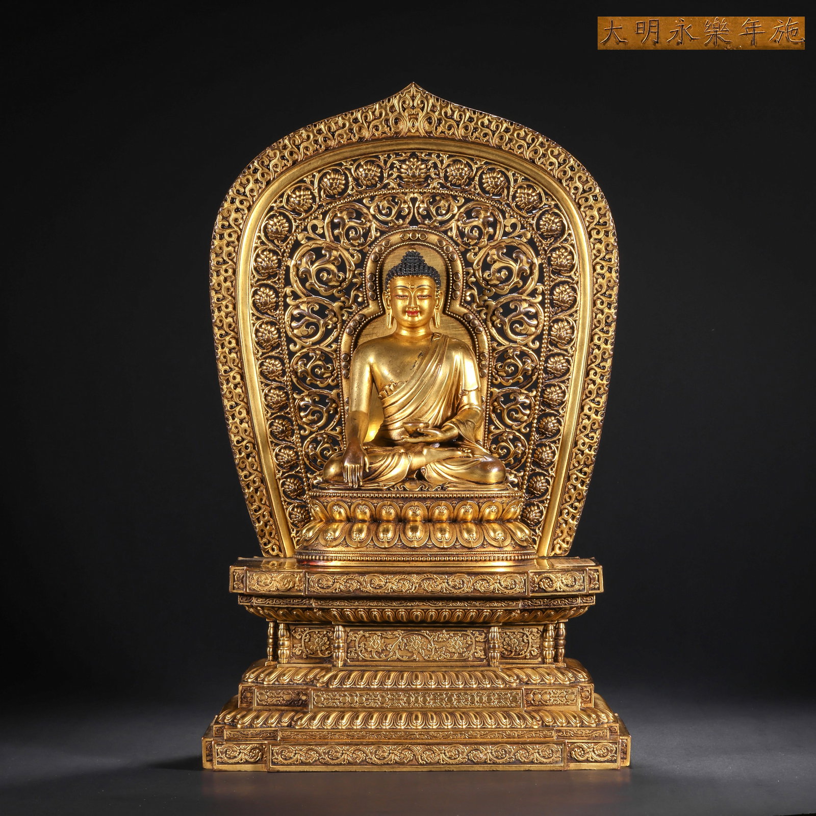 A GILDED BRONZE STATUE OF THE ENLIGHTENMENT OF SAKYAMUNI BUDDHA FROM THE MING DYNASTY: H:32.0cm(12.60in) W:20.0cm(7.87in) Weight:3250g(7.17lb)This statue is cast in bronze and gilded. Sakyamuni Buddha sits in the full-lotus posture on a double-layer lotus pedestal, with the right hand i