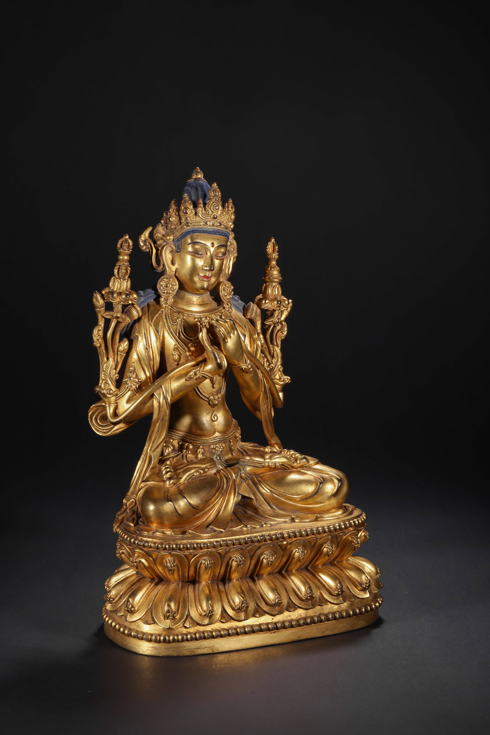 A GILDED BRONZE STATUE OF MANJUSRI BODHISATTVA FROM YONGLE, MING DYNASTY: H:29.0cm(11.42in) W:17.0cm(6.69in) Weight:3500g(7.72lb)This statue is cast in bronze and gilded. Manjushri sits in lotus position on a double lotus pedestal, wearing a treasure crown inlaid with blue 