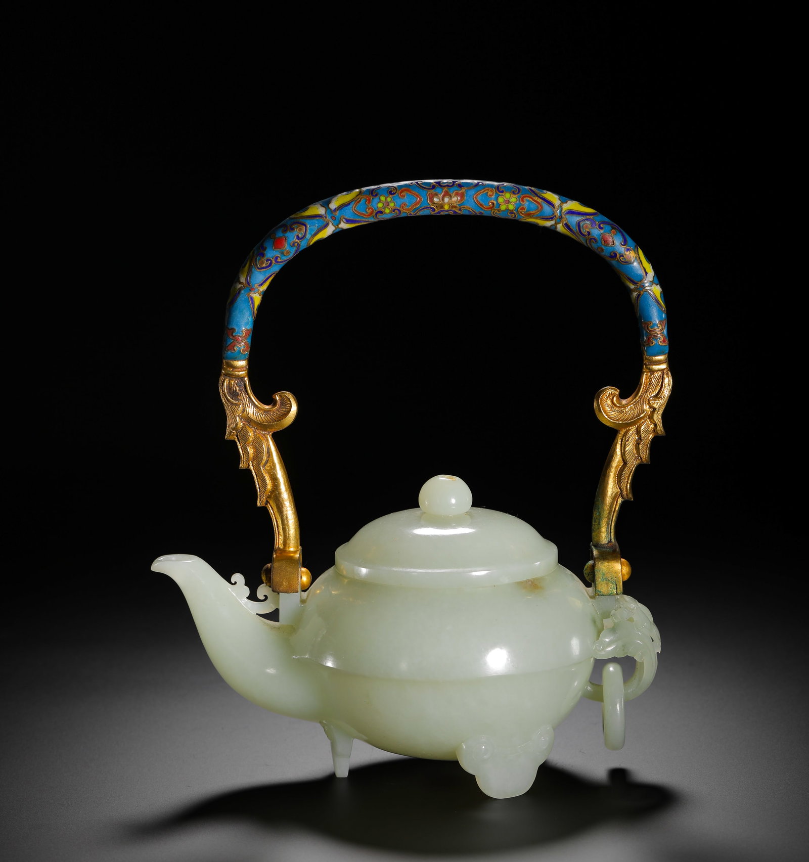 QING DYNASTY QIANLONG HETIAN JADE CLOISONNE ENAMEL HANDLE POT: H:19cmW:16cmWeight:530g This imperial teapot from the Qianlong period of the Qing Dynasty is crafted from lustrous Hetian white jade, with a handle made of gilt copper and cloisonné enamel, and bears