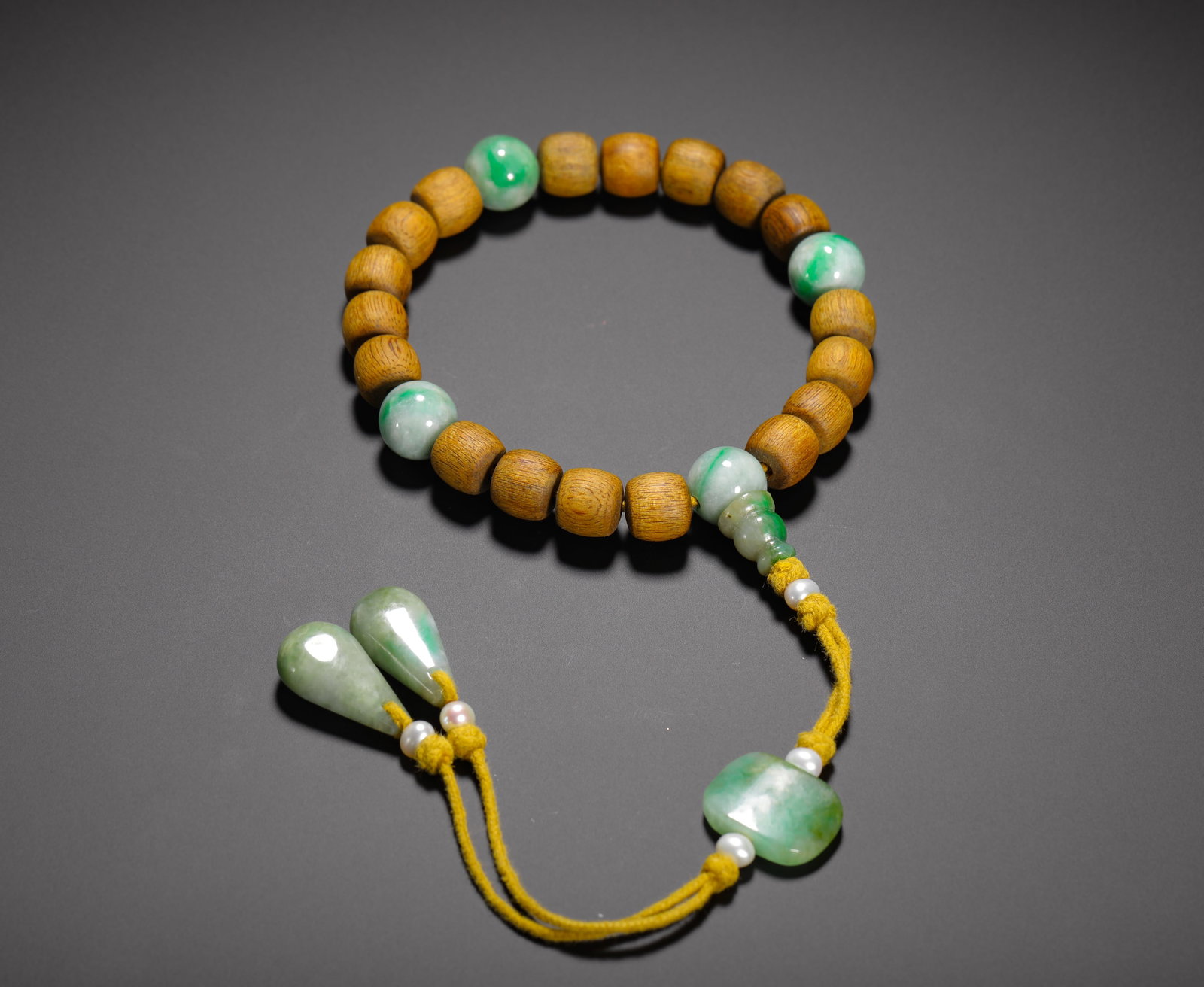 QING DYNASTY AGARWOOD INLAID JADE EIGHTEEN BEADS BRACELET: D:1.1cm(0.4331in) Weight:40g(0.09lb)This is an eighteen-bead agarwood bracelet with jadeite inlay from the Qing dynasty, an elegant object combining scholar’s accessories with imperial craftsmanship