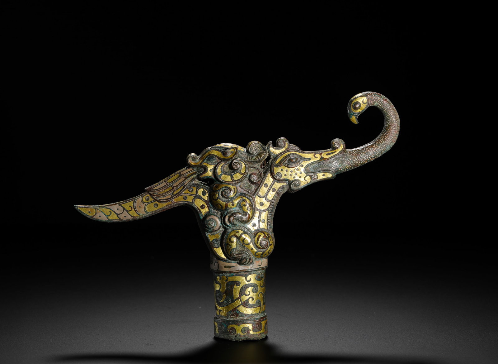 FROM THE WARRING STATES PERIOD, INLAID GOLD AND SILVER DRAGON AND PHOENIX COMPOUND HEAD GOBI ð: H:13cm (5.12in) W:20cm (7.87in) Weight:510g (1.12lb)Bronze cane finial with composite dragon & phoenix design, elaborately inlaid gold scroll patterns, socket base for wooden staff.