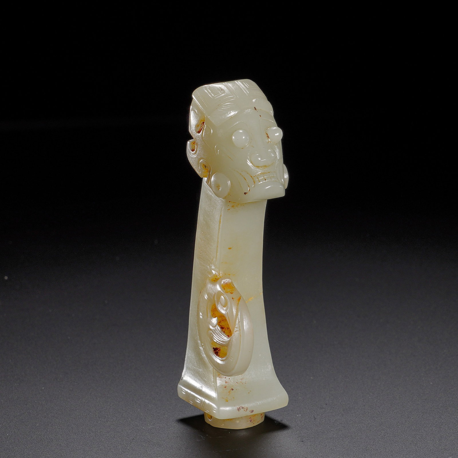 SHANG AND ZHOU HETIAN JADE DIVINE HUMAN HEAD HANDLE-SHAPED VESSEL: Height:8.5cm(3.35in), Width:3.5cm(1.38in), Weight:60g(0.132lb)Carved from Hetian jade, this handle?shaped ornament has fair mild texture dotted with natural yellow?brown patina and mellow aged gloss. 