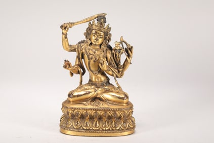 A MING DYNASTY GILDED FOUR-ARMED MANJUSRI BODHISATTVA