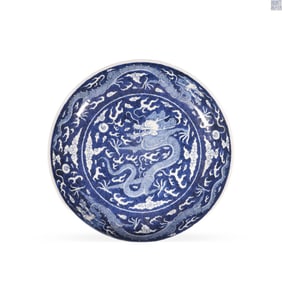 Qing Daoguang blue and white plate with a cloud and dragon motif on a reserved white ground
