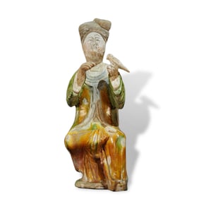 Tang Dynasty Tri-color seated female figurine holding a bird