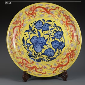 LARGE QING DYNASTY YELLOW-GROUND BLUE AND WHITE PEACH AND FIVE DRAGON PATTERN PLATE