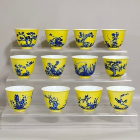 A SET OF TWELVE FLOWER GODDESS CUPS IN BLUE AND YELLOW GLAZE FROM THE QING DYNASTY