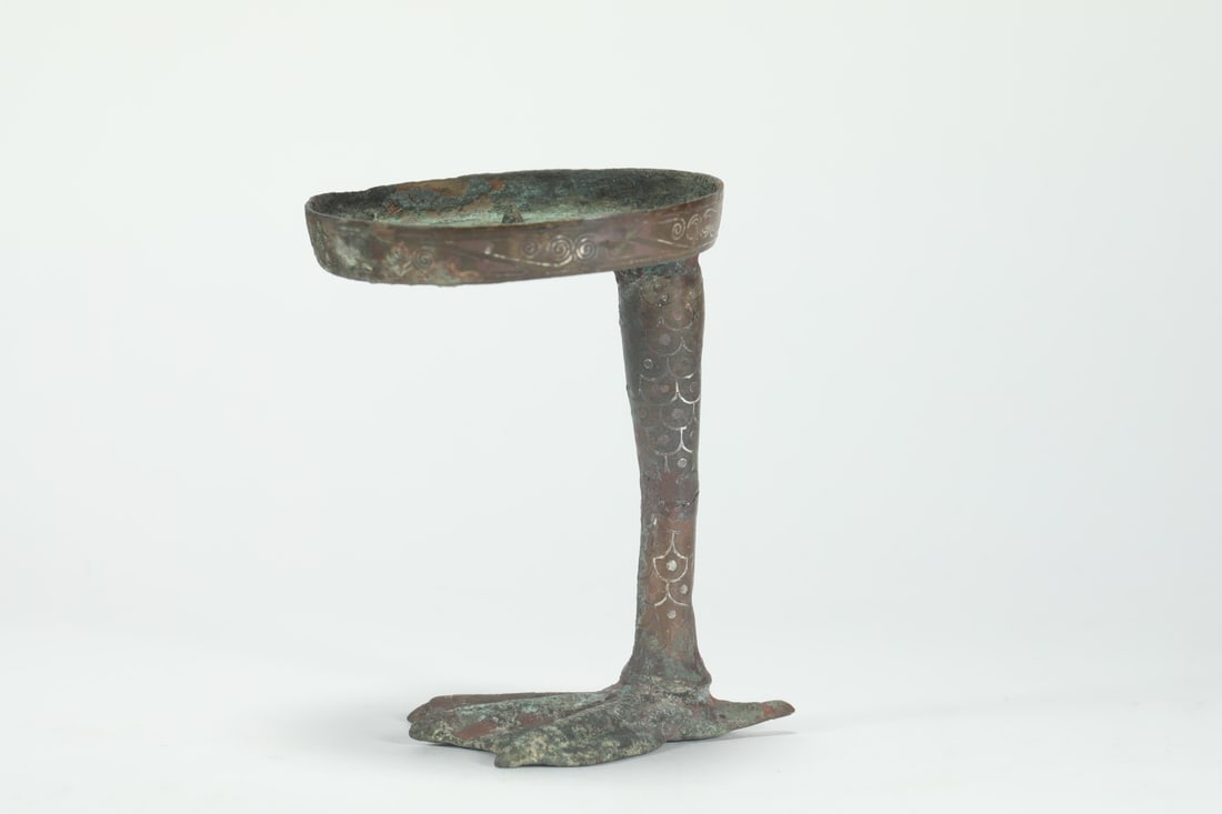 WARRING STATES PERIOD BRONZE INLAID SILVER GOOSE-FOOT LAMP: Name WARRING STATES PERIOD BRONZE INLAID SILVER GOOSE-FOOT LAMP Dimensions H:9.5CM L:7.5CM Condition Additional photographs and condition reports are available upon request as a cour