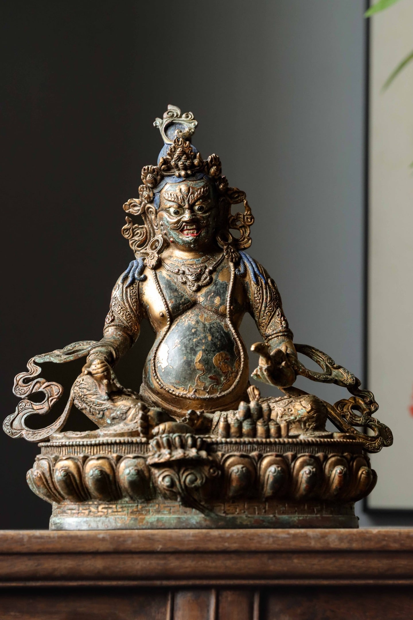 GILDED BRONZE STATUE OF THE YELLOW GOD OF WEALTH FROM THE QING DYNASTY: Weight: 3000g (6.61lb) H: 27.5cm (10.83in) W: 24cm (9.45in) T: 13.5cm (5.31in)Cast bronze with partial gilding and blue pigment on hair; seated on double lotus base, the foremost of five major Tibetan