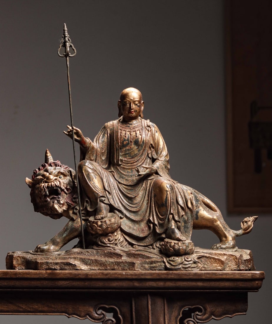 GILDED BRONZE FROM THE QING DYNASTY A STATUE OF THE BODHISATTVA KING DI ZANG RIDING DI TING: Weight: 5300g (11.68lb) H: 39cm (15.35in) H: 31cm (12.20in) W: 39cm (15.35in) T: 17cm (6.69in)Finely cast copper with lacquer gilding; Ksitigarbha rests atop mythical beast Diting beside nine-ringed m