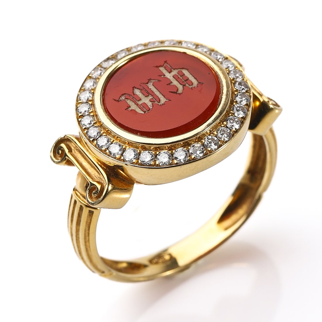 AN 18K GOLD, CARNELIAN AND DIAMOND RING: Dimensions Inner diameter: 16.9 mm; Bezel diameter: 3/8 in. (9.7 mm); Weight: 4.5 g Description Centering an oval red carnelian intaglio engraved with stylized characters, encircled by a border of bri