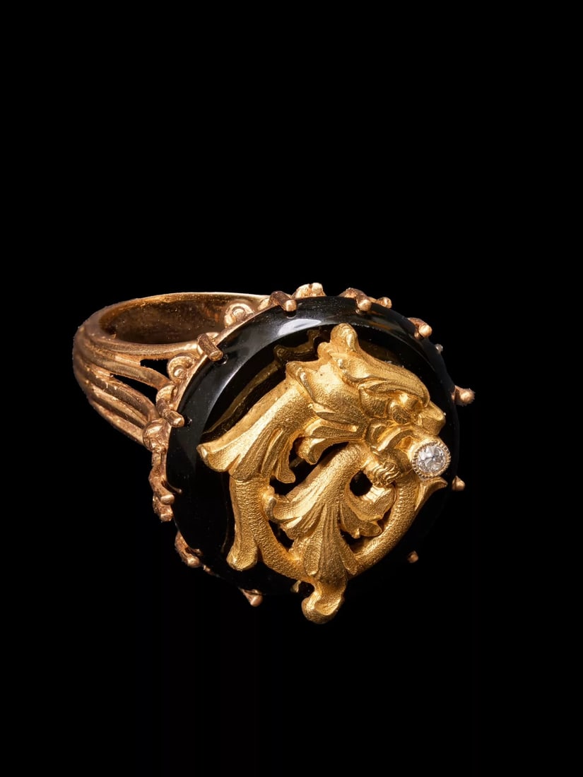 French 20th-Century Art Nouveau 18K Chased-Gold Chimera Diamond and Onyx Ring: Ring Size: US 7.5-8 Designed with a relief-carved head of the Greek mythical beast Chimera, diamonds are set within the creature's open jaws. The shank features grille-style open-work, and the bezel i