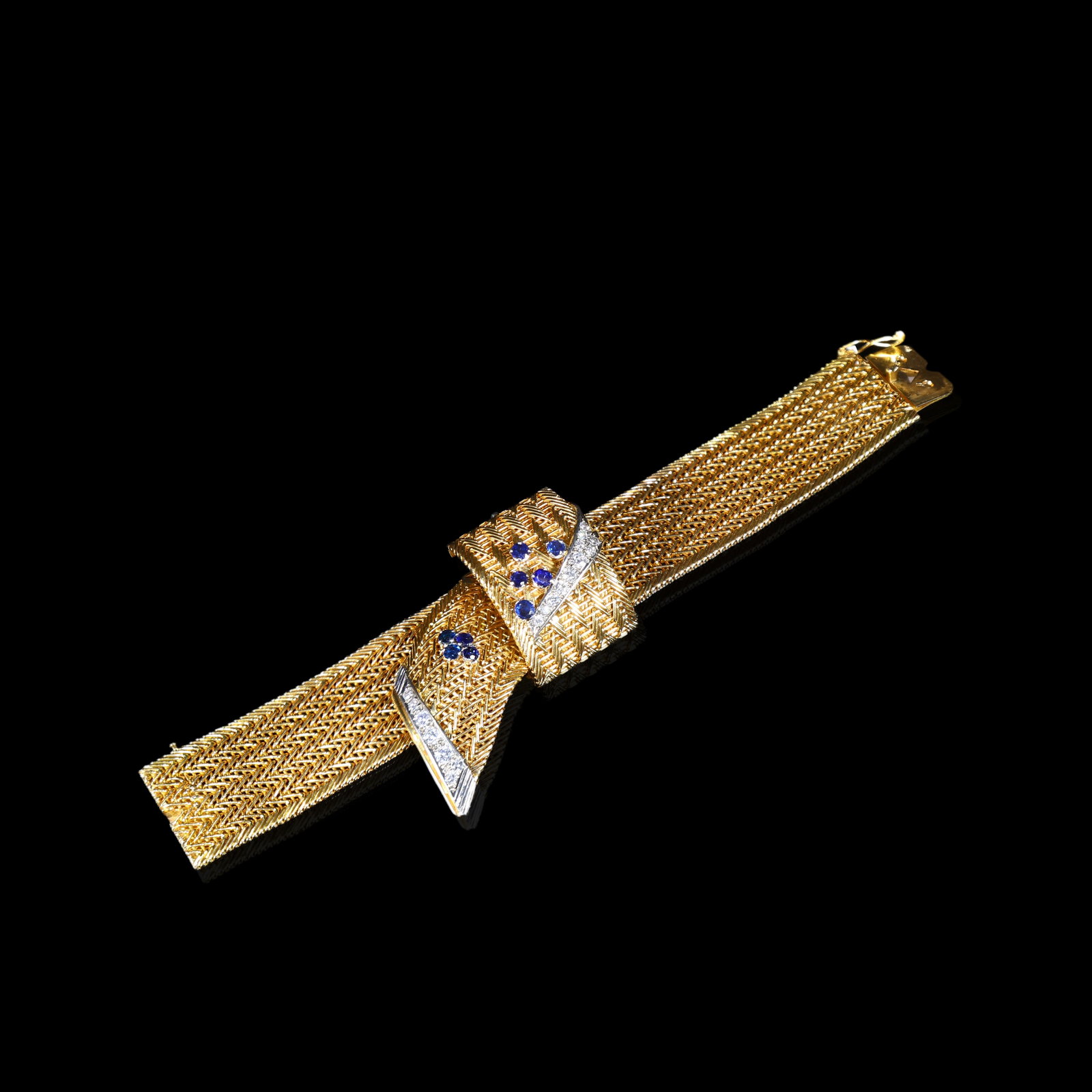 Mid-20th-Century Swiss Omega 18K Gold Custom-Built Concealed Sapphire and Diamond Wristwatch: Inner Length:17.8cm Bracelet Width:4.8cm Dial Diameter:1.2cm Wt:112g Set with sapphires totalling approximately 1 ct and diamonds totalling approximately 1.5 ct.