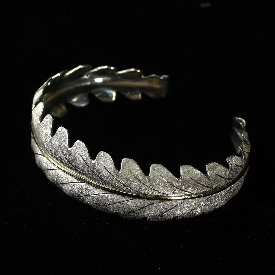 Antique Mixed-Metal Leaf-Chased Bangle by Federico Buccellati: Suitable for wrist circumference within 16.5 cm Wt:23.6g Work by Federico Buccellati. Entirely hand-crafted in 18K gold and sterling-silver (925). Bears Federico Buccellati's hand-engraved signature, 