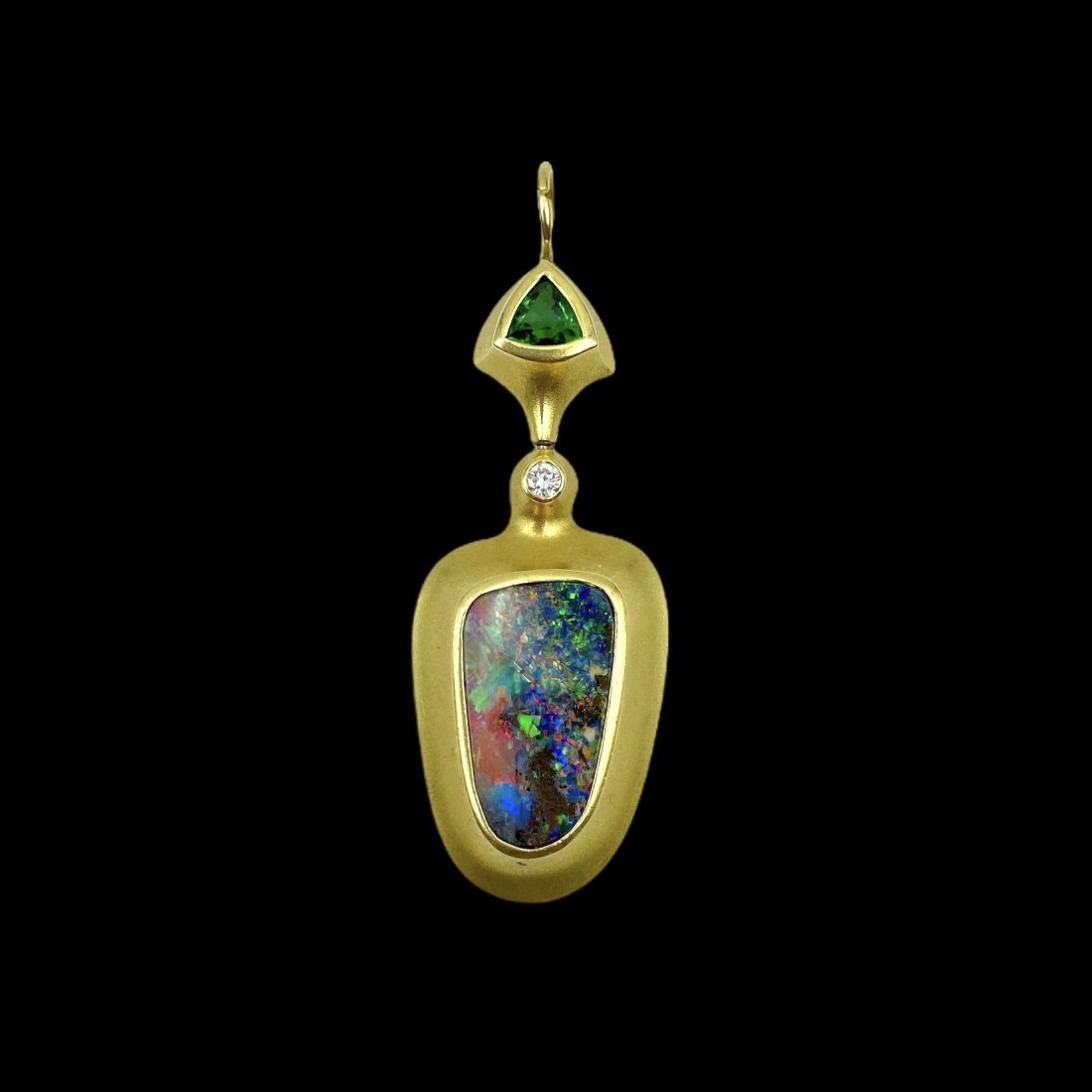 Vintage Gold Solid Black Opal Pendant: 18K. With an excellent apx 3 1/2 carat Black Opal exhibiting remarkably strong color accented with a brilliant cut diamond and green Tourmaline. Measures 2 in L. x 3/4 in. W. Weight 7.7g.