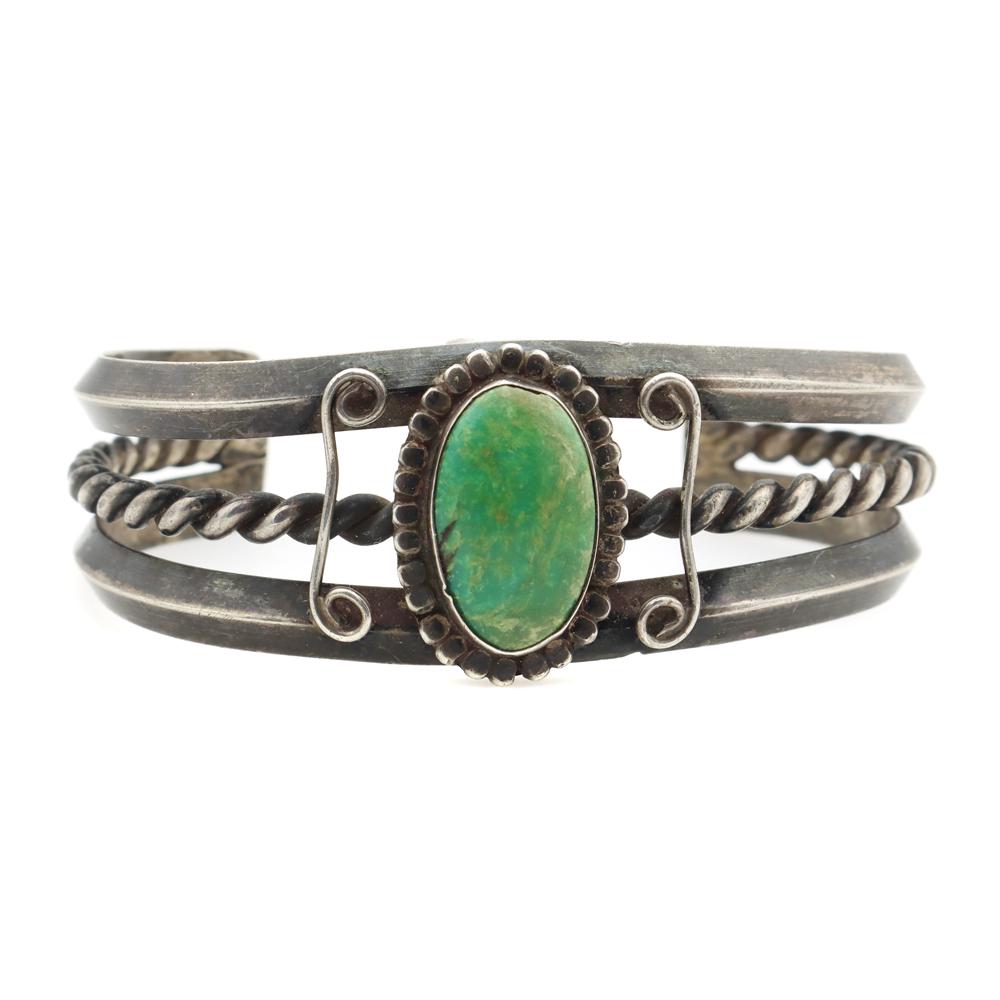 Navajo Turquoise and Silver Bracelet: Navajo Turquoise and Silver Bracelet with Rope Design c. 1930s, 40.9 grams, 1" bandwidth, size 6.5 to include a gap of 1.5". The turquoise stone measures 18mm x 11mm (0.71" x 0.43"). The silver has ac