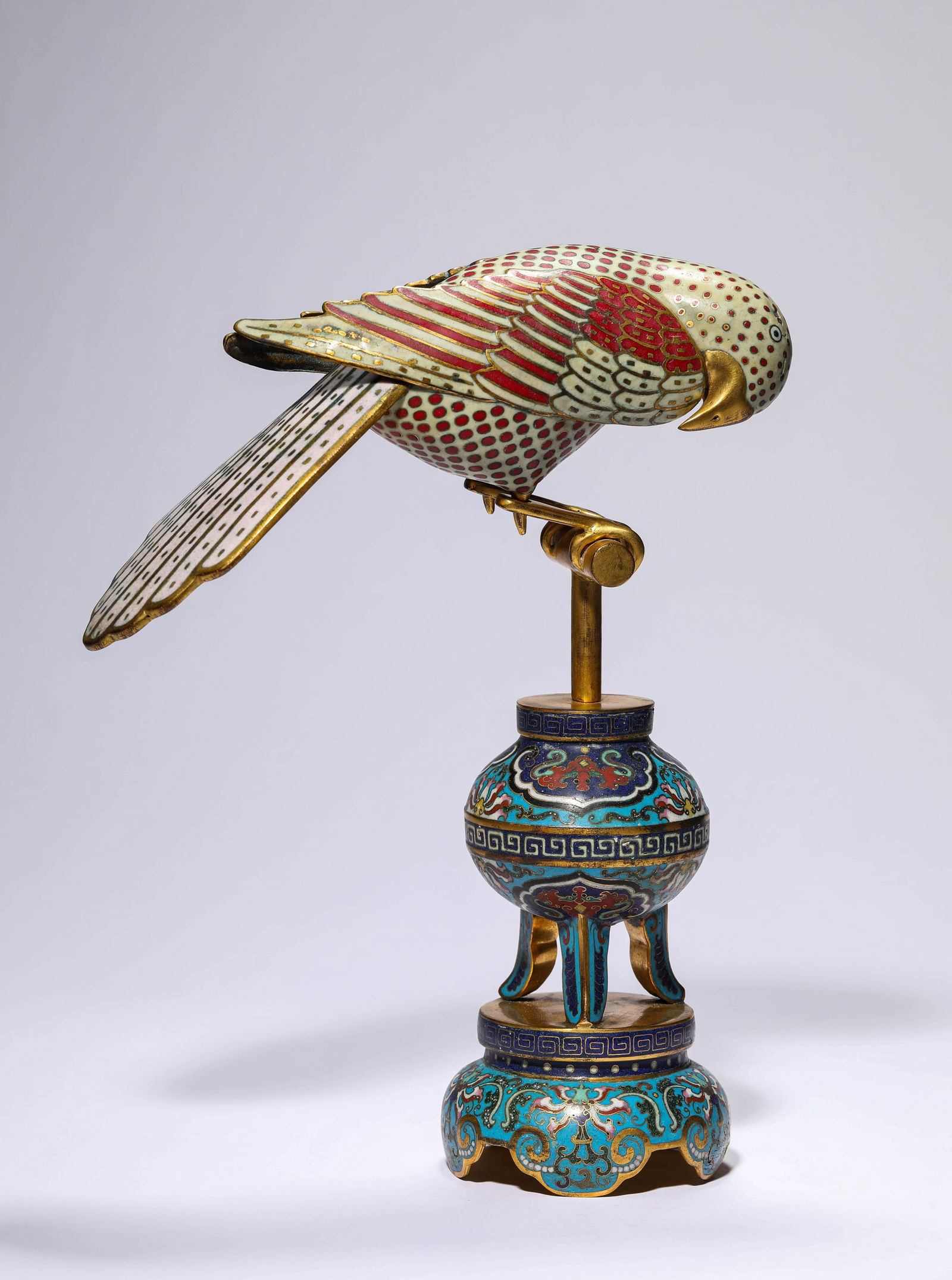 A Cloisonne Enamel Parrot Sculpture: A Cloisonne Enamel Parrot Sculpture Weightï¼š1152g Long:21cm Wide:9.3cm Height:29.5cmThe parrot is decorated on the tripot censer with its head lowered to the ground and the wings backwards.