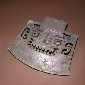 A BRONZE BEAST FACETED AXE