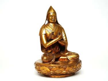 A GILT BRONZE FIGURE OF GURU