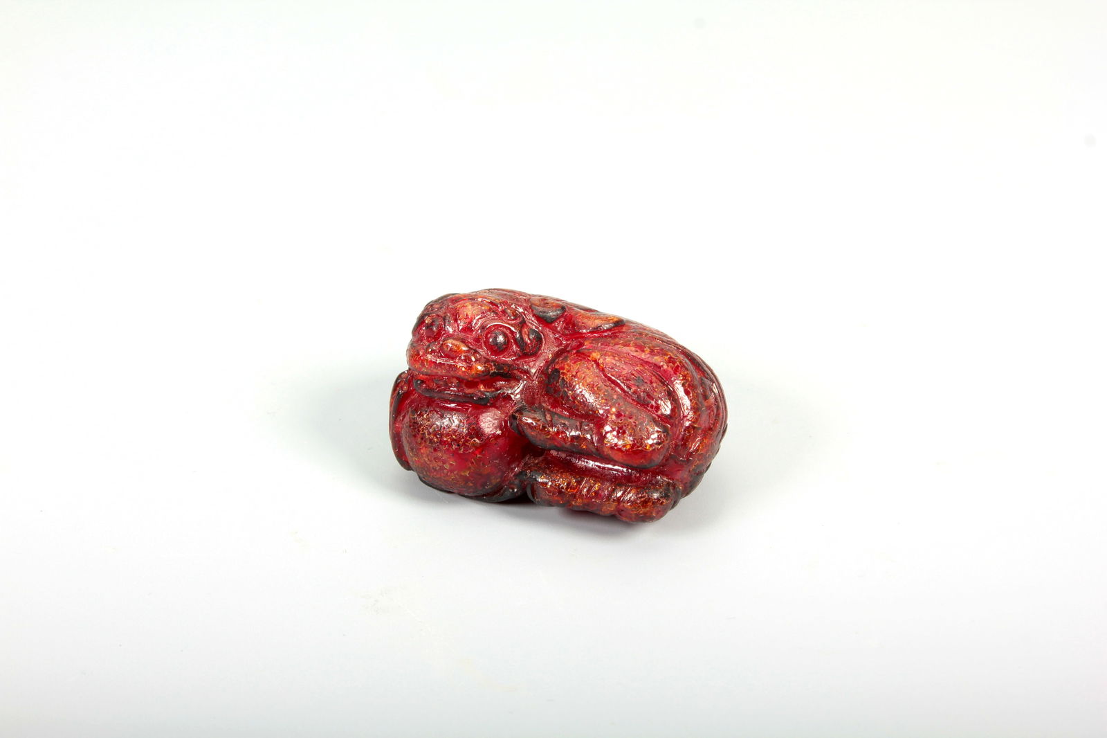 AN AMBER LION AND BALL CARVING