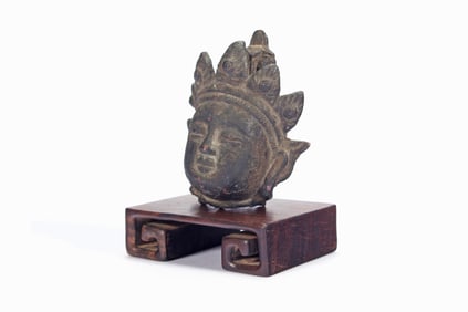 A BRONZE BUDDA HEAD ROSEWOOD SCROLL-SHAPED BASE