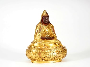 A GILT BRONZE FIGURE OF GURU