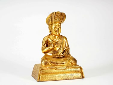 A GILT BRONZE FIGURE OF GURU