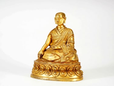 A GILT BRONZE FIGURE OF GURU
