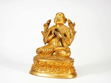 A GILT BRONZE FIGURE OF GURU