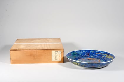 A BLUE-AND-WHITE DISK WITH OVERGLADE COLORED CLOUD-DRAGON PATTERN